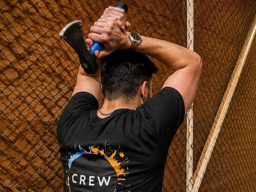 Crew-Mitglied von Axtwerfen Hamburg holt mit der Axt zum Wurf aus