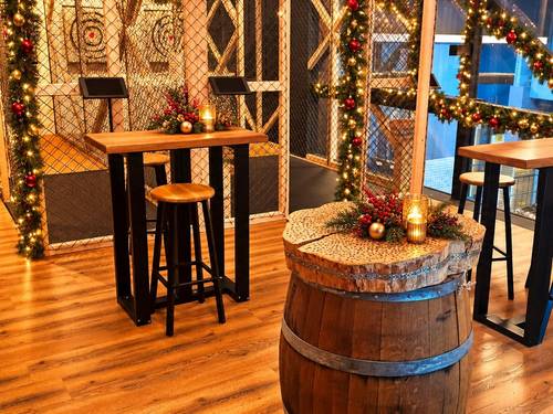Weihnachtlich geschmückter Lounge-Bereich mit Stehtischen bei Axtwerfen Hamburg